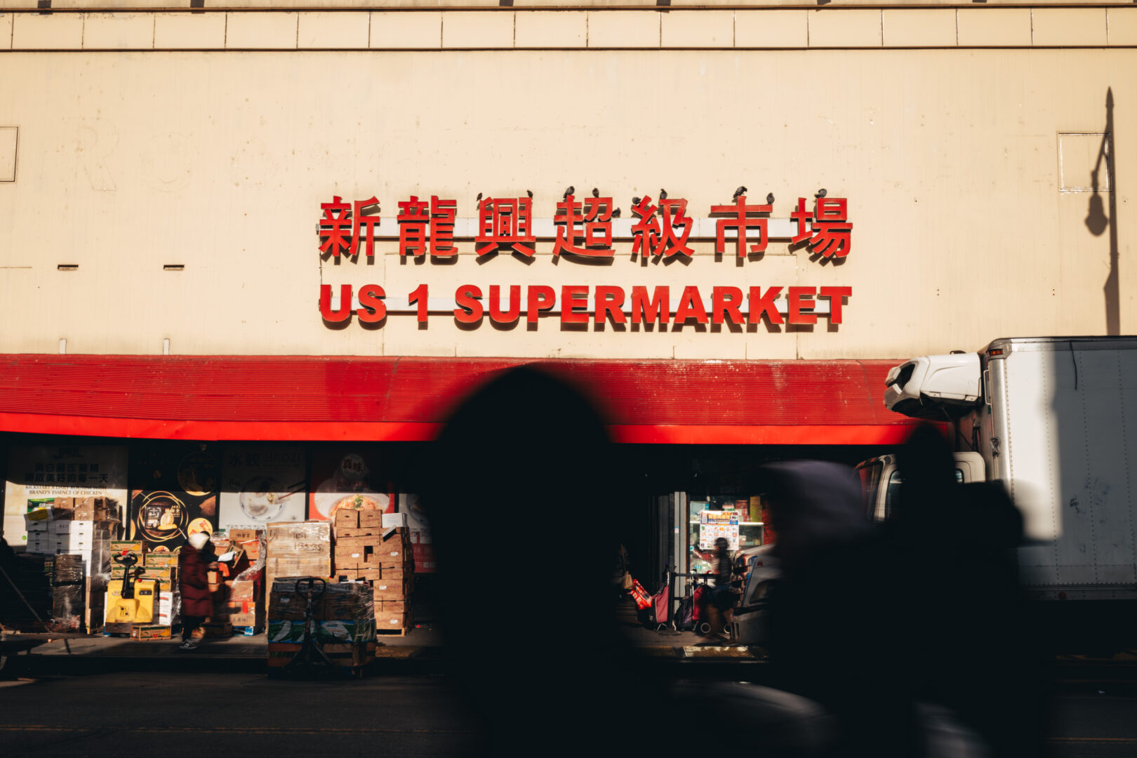 US 1 Supermarket, Queens
Pedestrians move past a neighborhood supermarket during delivery hours.