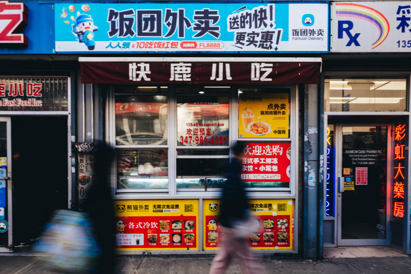 Restaurant facade, Roosevelt Avenue, Queens
Blurred figures pass along a busy commercial corridor.